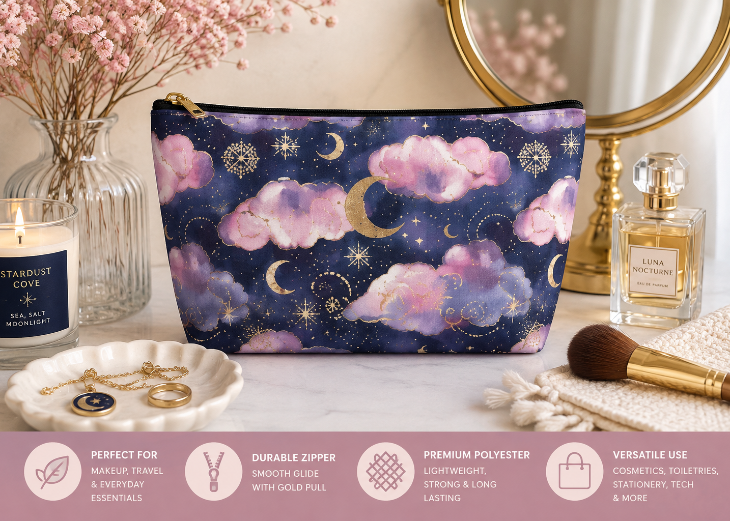 A zippered cosmetic pouch with a celestial print of pink clouds, gold moons, and stars on a dark blue background, styled on a marble surface with a candle, perfume, and makeup accessories. A pink banner at the bottom lists product features.