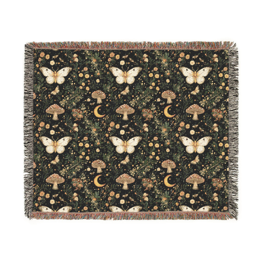 A rectangular woven throw blanket with fringed edges, featuring a dark forest pattern with cream butterflies, brown mushrooms, and small gold crescent moons and dots on a black background.