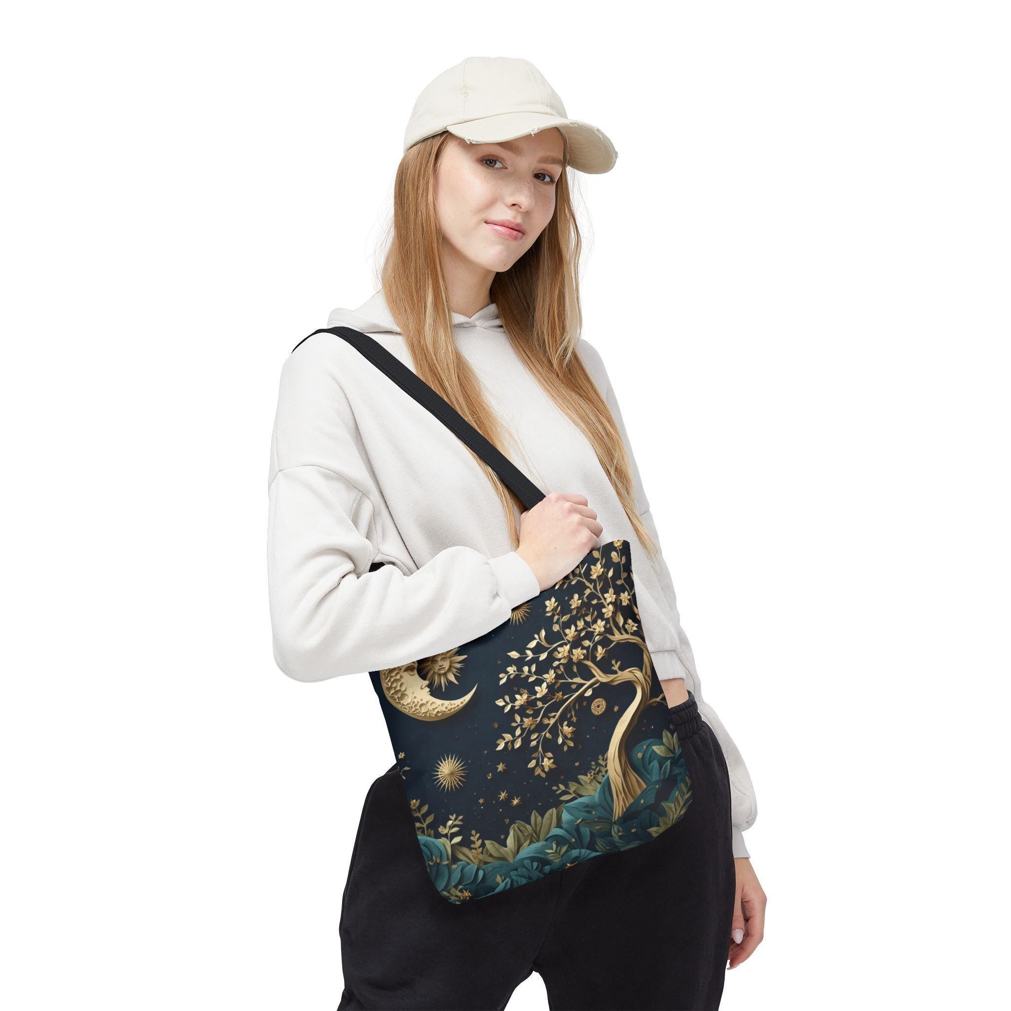Woman wearing cap carrying Celestial Moon Tree of Life Tote Bag — boho witchy navy canvas tote with gold tree design
