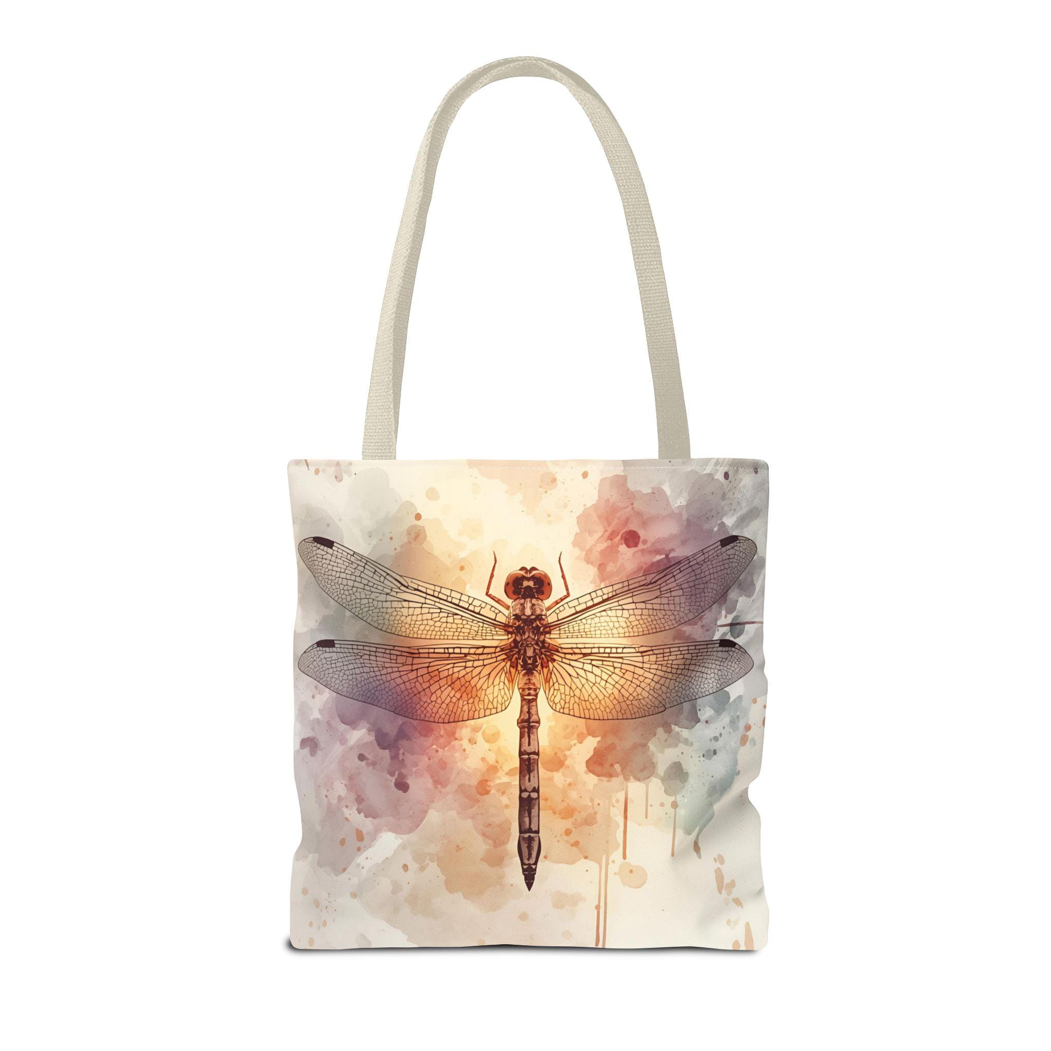 Watercolor Dragonfly Tote Bag flat lay — vintage dragonfly illustration on soft watercolor wash background in cream, blush, and sage tones, natural canvas handle
