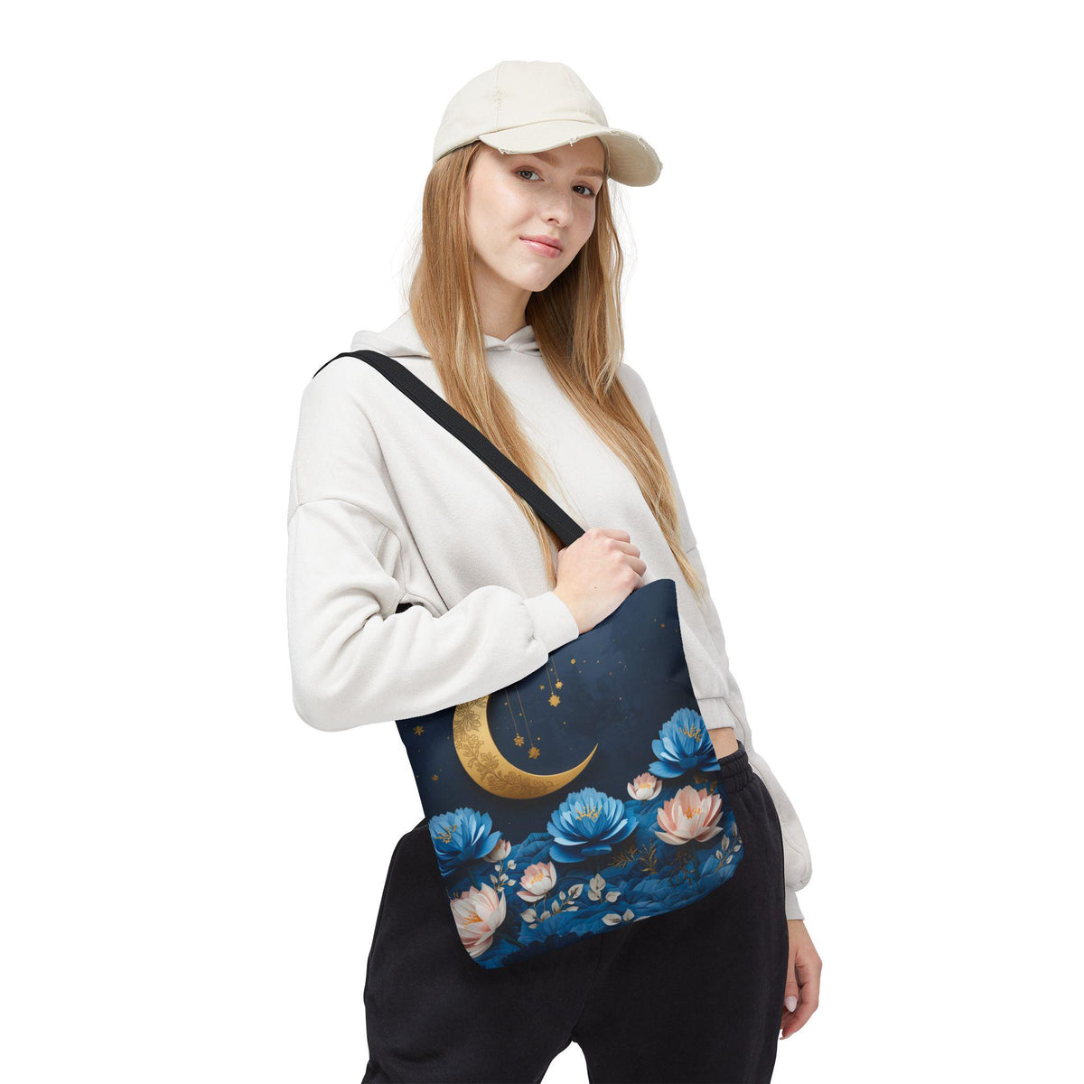 Woman holding a tote bag with floral and moon design on a white background