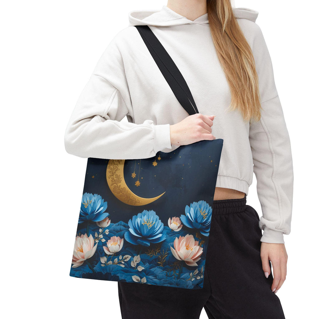 Person wearing a white hoodie with a blue tote bag featuring floral and moon design.