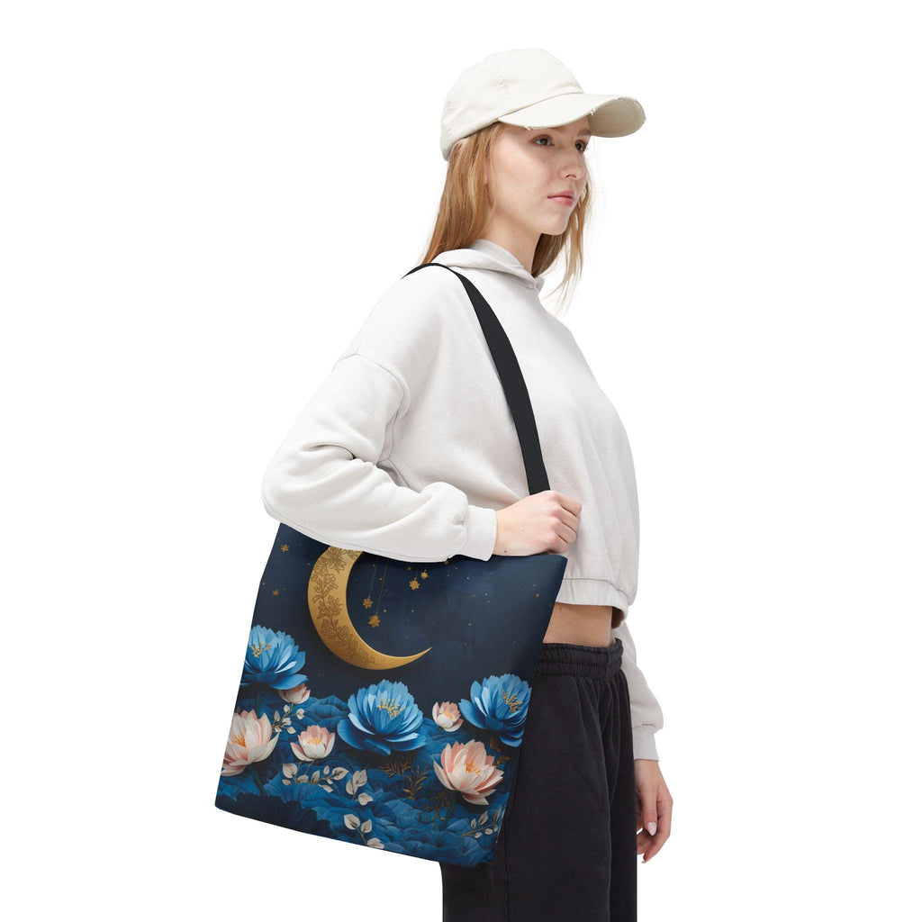 Person holding a tote bag with floral and moon design on a white background