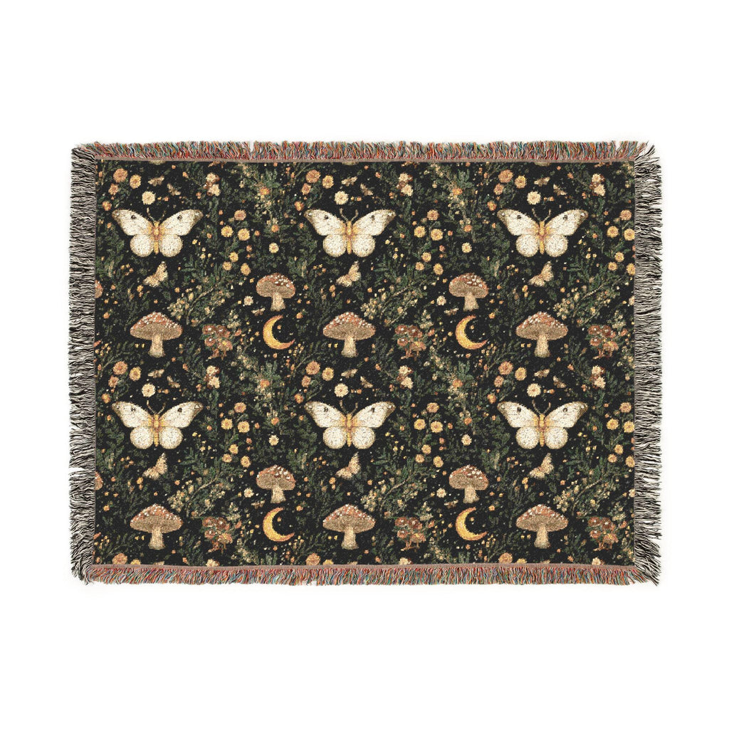 A rectangular woven throw blanket with fringe edges, featuring a dark forest pattern with cream butterflies, brown mushrooms, and gold crescent moons on a black background.