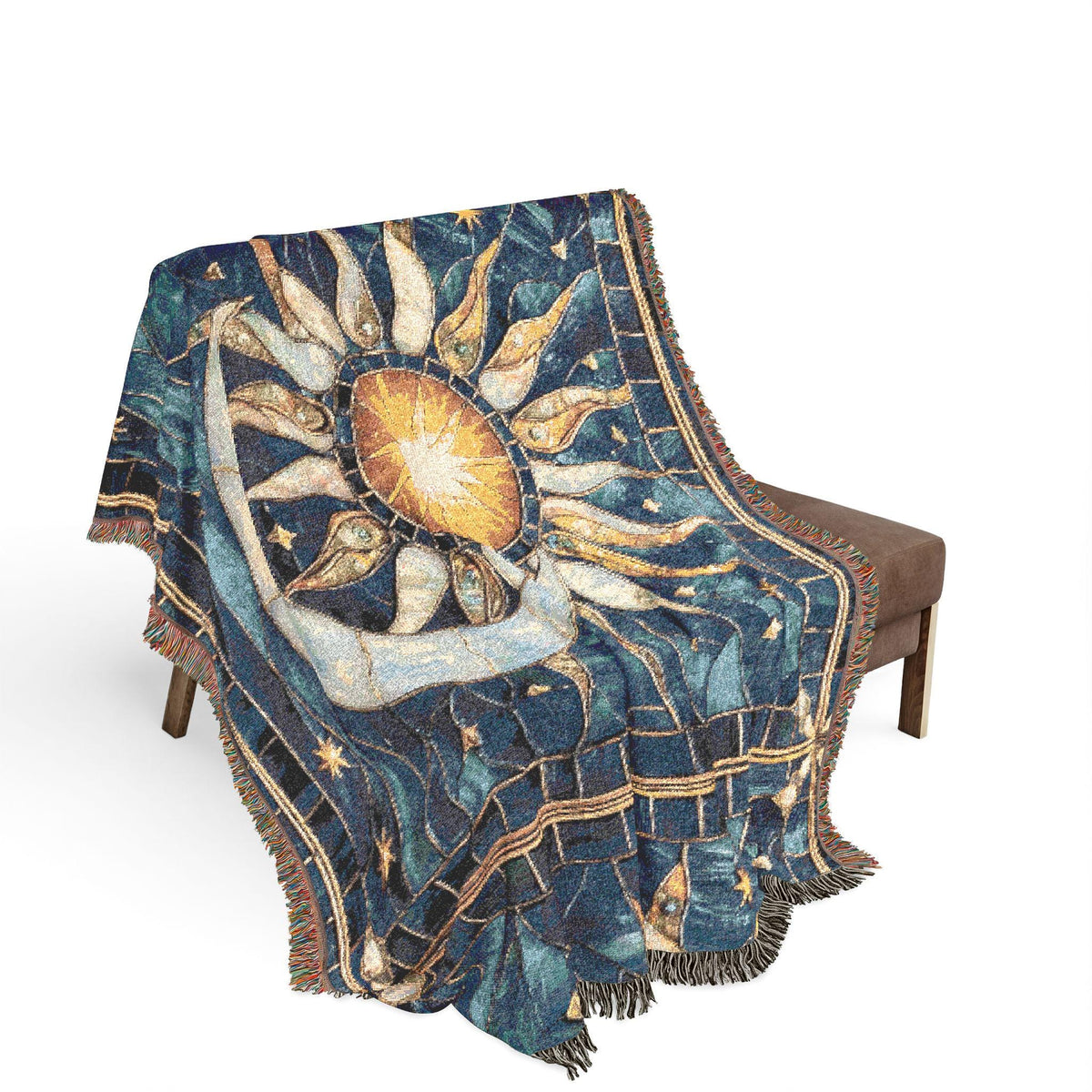 A woven throw blanket with a celestial sun and moon design draped over a brown bench against a white background.