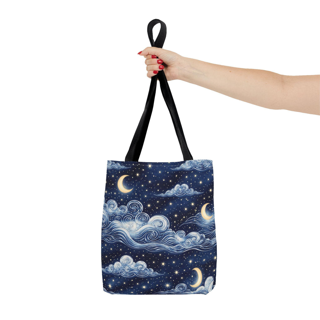 Moon and whimsical clouds tote bag held by hand — navy night sky swirling clouds and crescent moon print tote