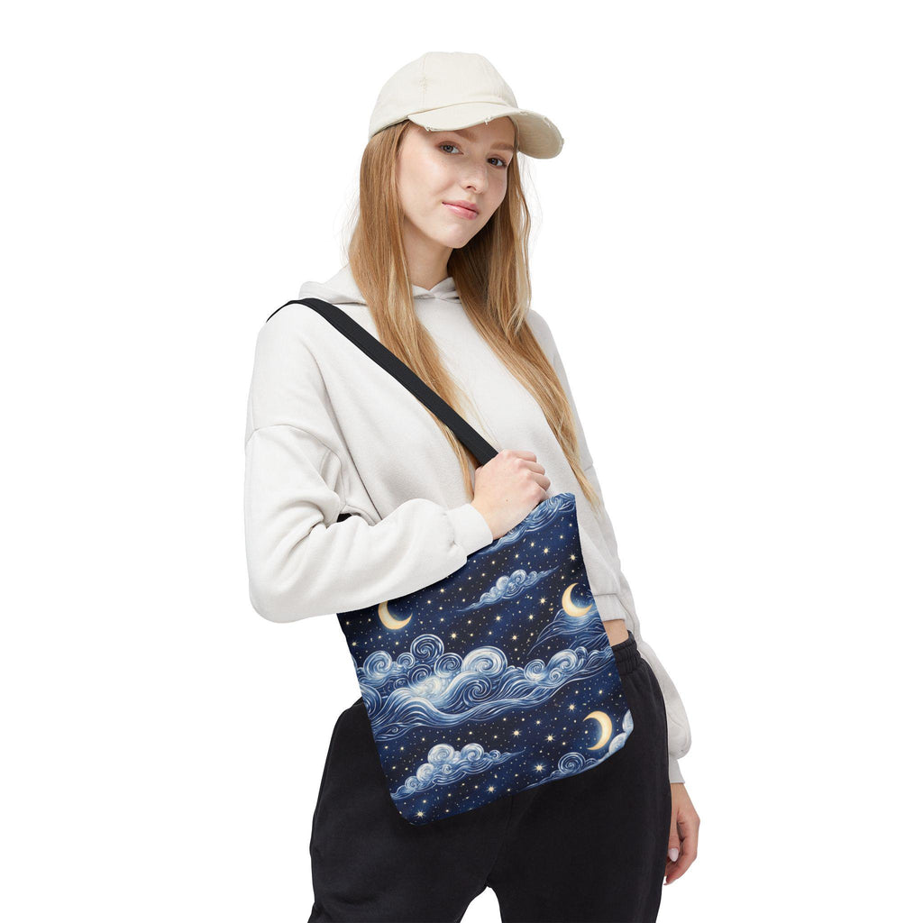Moon and whimsical clouds tote bag worn over shoulder — woman in casual outfit with navy night sky star print tote