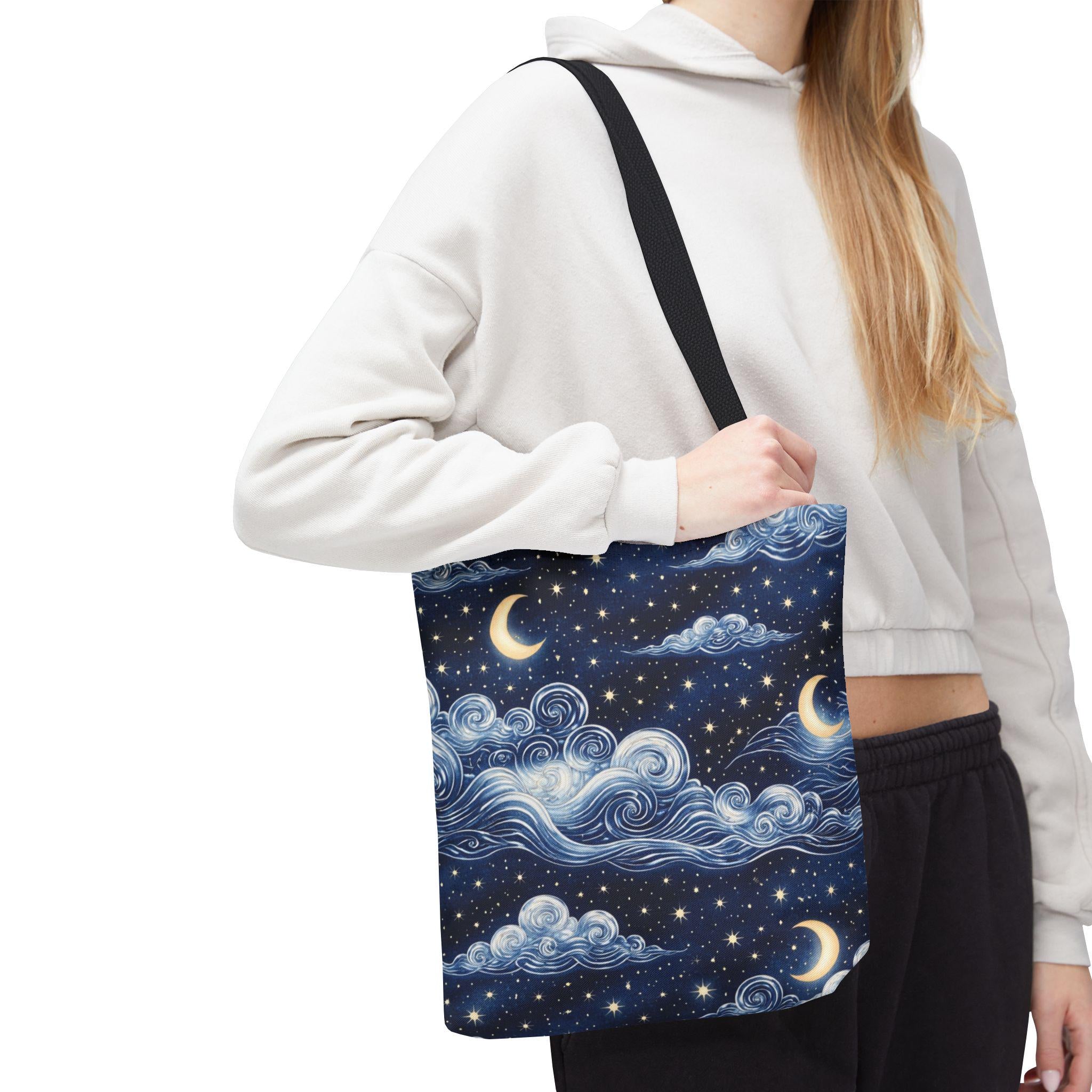 Moon and whimsical clouds tote bag close-up lifestyle — navy tote with swirling clouds crescent moon and star print shown at side
