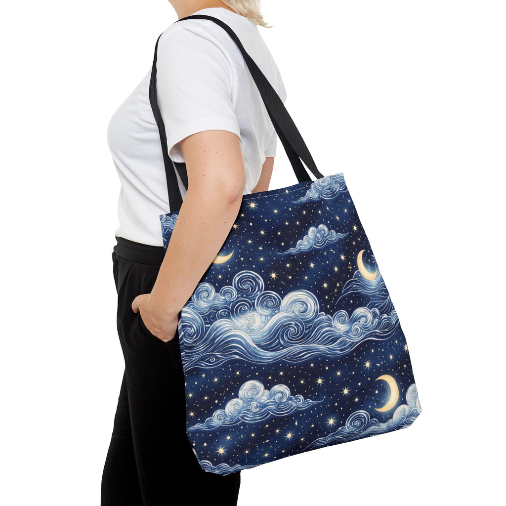 Moon and whimsical clouds tote bag worn over shoulder front view — navy night sky swirling clouds crescent moon and star print tote
