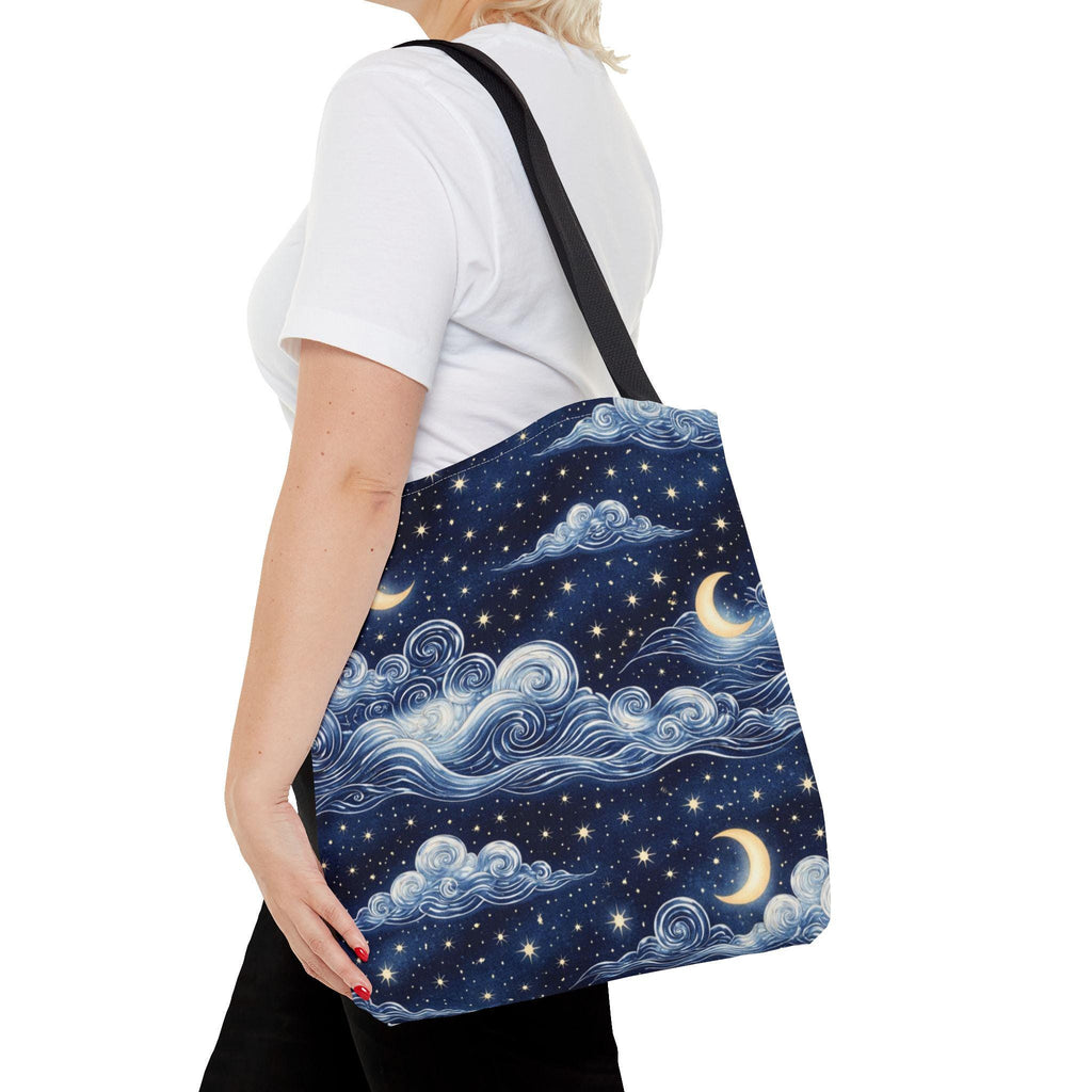Moon and whimsical clouds tote bag worn over shoulder — side view showing full navy night sky cloud and crescent moon print