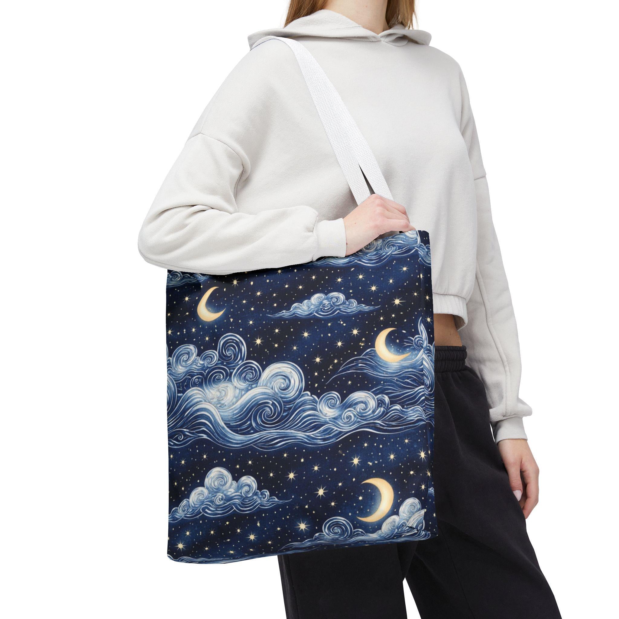 Moon and whimsical clouds tote bag with white handle — woman carrying navy night sky swirling clouds and crescent moon print tote
